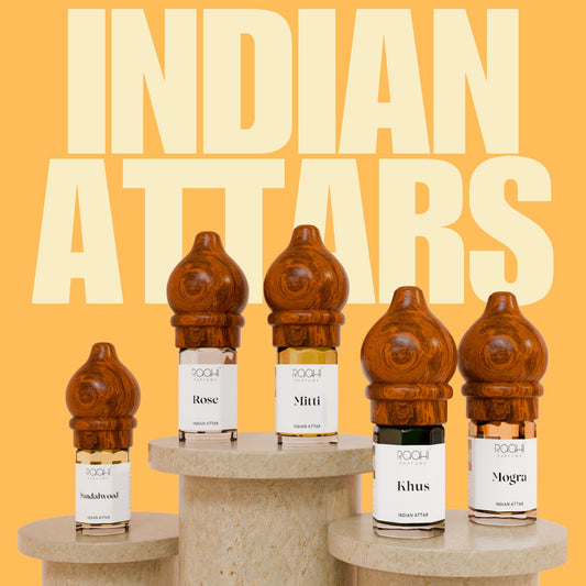 Wooden-hued intricately carved bottle caps on clear glass vials of amber and dark liquid perfumes traditional indian attars set