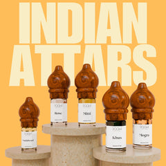 Wooden-hued intricately carved bottle caps on clear glass vials of amber and dark liquid perfumes traditional indian attars set