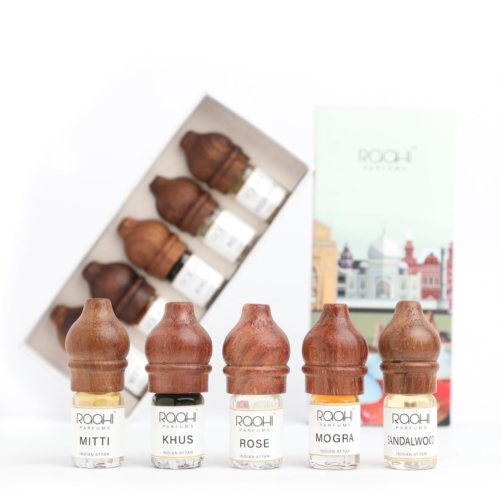 Five wooden-capped clear glass perfume bottles from rochi parfums handcrafted in kannauj india traditional Indian attars set