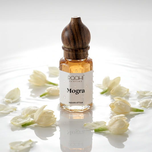 A small hexagonal glass bottle of roohi parfums mogra indian attar with amber liquid and dark wood cap handcrafted in kannauj