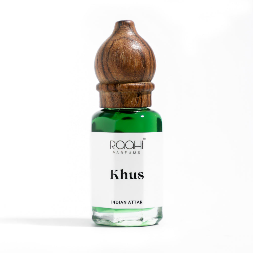 A small green glass bottle with wooden cap labeled khush indian attar by raahi parfums handcrafted in Kannauj