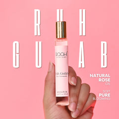 A slender pink glass bottle with gold cap and white label containing roahi parfums ruh gulab pure rose oil 12ml
