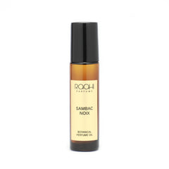 A sleek amber glass rollerball bottle with black cap and cream label of roohi parfums sambac noix botanical perfume oil