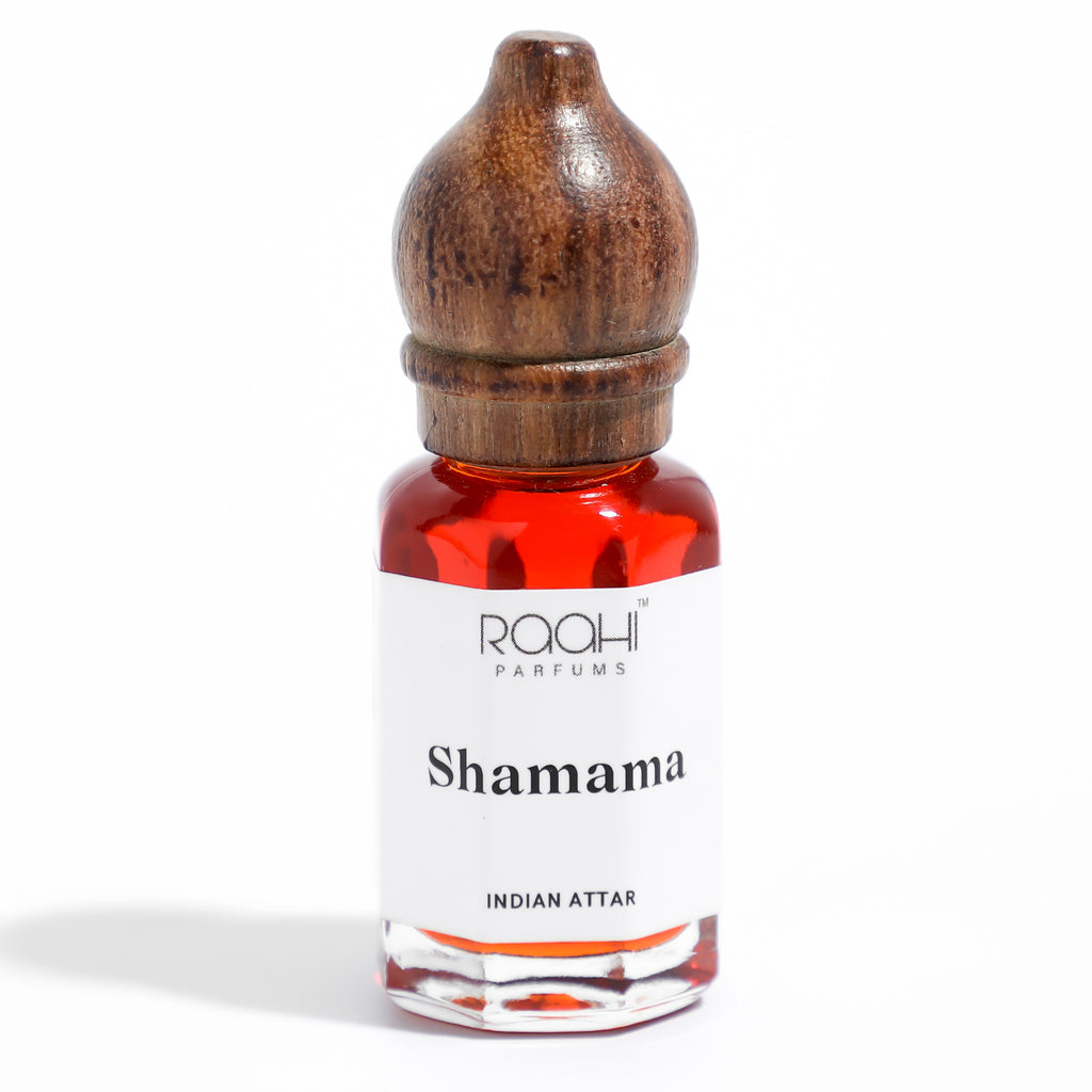 A small glass bottle with a polished wooden stopper containing vibrant red shamama attar by raahi parfums