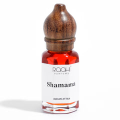 A small glass bottle with a polished wooden stopper containing vibrant red shamama attar by raahi parfums