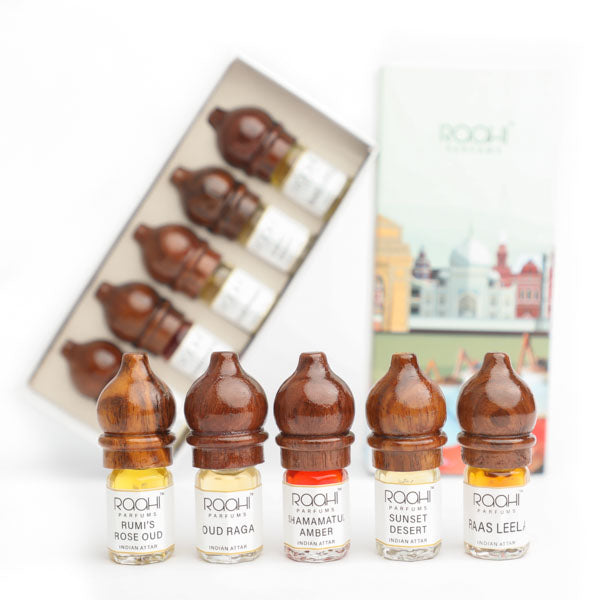 Five amber wooden-capped Roohi Parfums signature attars vials with clear glass bodies handcrafted in Kannauj India