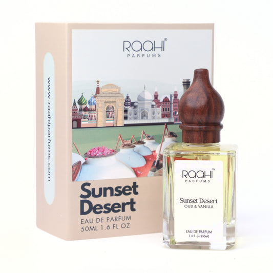 A clear glass bottle of raahi parfums sunset desert oud and vanilla eau de parfum with dark brown wooden stopper and white label