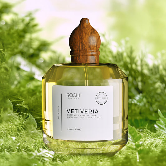 A clear glass bottle of Rqohi Parfums Vetiveria eau de parfum with a polished wooden cap and golden-yellow liquid