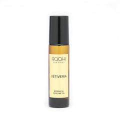 A sleek amber glass rollerball bottle with black cap and cream label of roohi parfums vétiveria botanical perfume oil