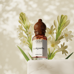 A sleek glass bottle of roohi parfums rajnigandha tuberose attar with rich amber liquid and dark wood cap 12ml handcrafted